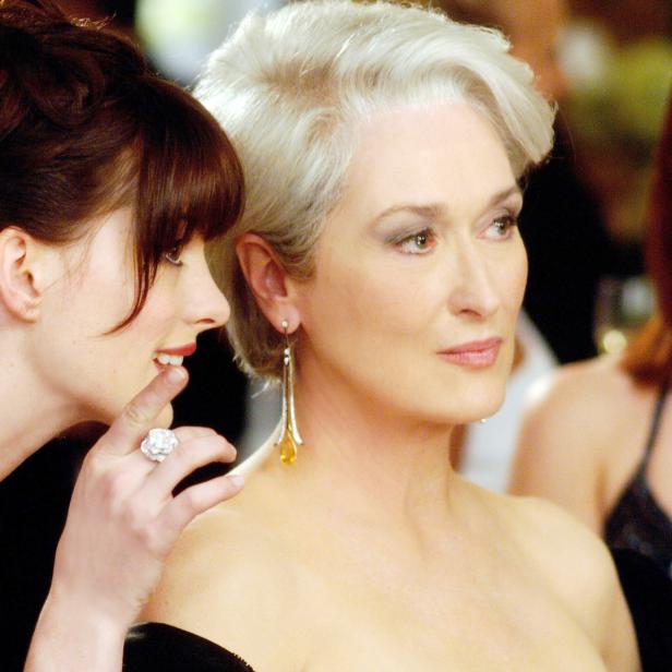 Anne Hathaway flüstert Meryl Streep etwas ins Ohr.