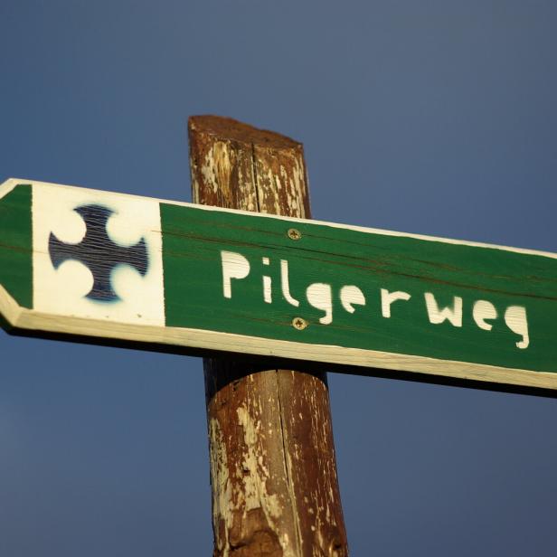 Schild mit Aufschrift Pilgerweg