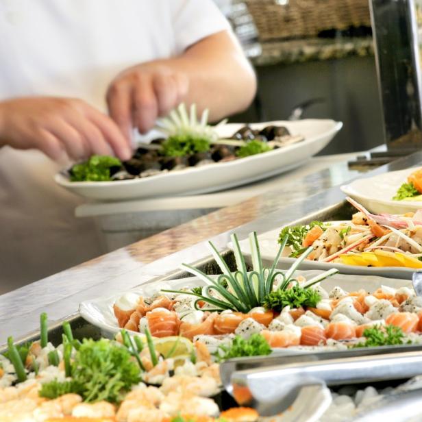 Ein Buffet mit verschiedenen Sushi- und Fischgerichten wird angerichtet.
