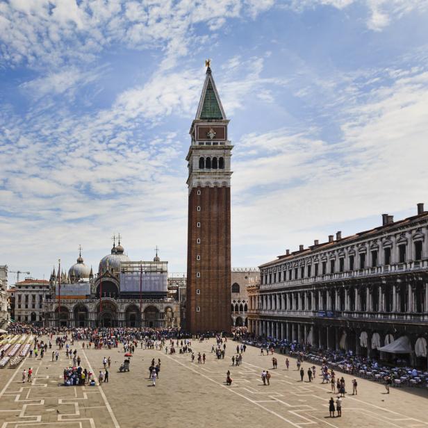 Der Markusplatz in Venedig mit dem Campanile und vielen Menschen.
