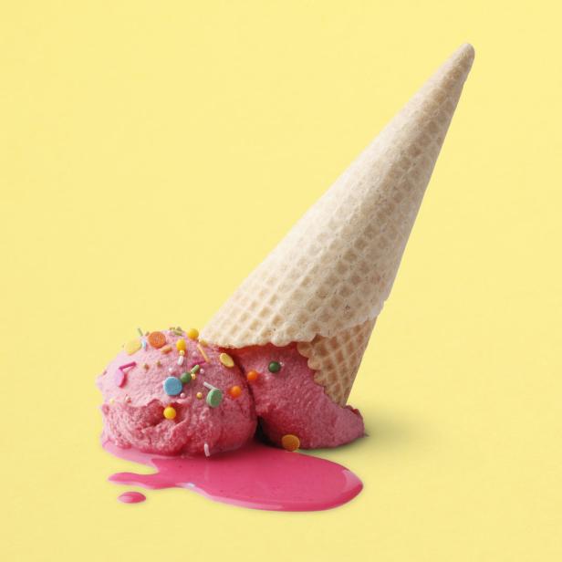Ein umgefallenes, rosa Eis mit Streuseln auf einem gelben Hintergrund.