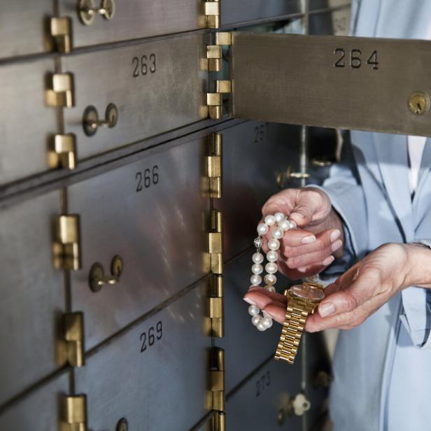 Frau legt Schmuck in ein Bankschließfach.
