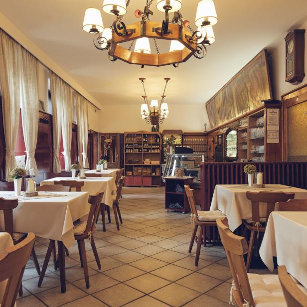 Ein traditionelles Restaurant mit gedeckten Tischen und holzvertäfelten Wänden.