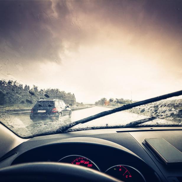 Blick aus dem Auto auf einen regnerischen Tag auf der Straße.