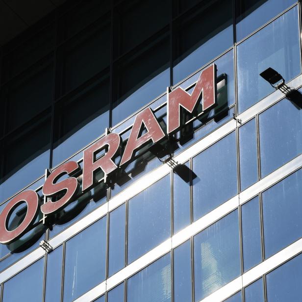 Das Osram-Logo an einem modernen Bürogebäude mit Glasfassade.