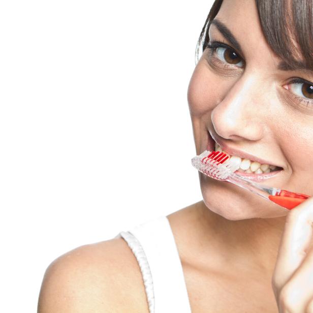 Das Bild zeigt eine Frau beim Zähneputzen. Viele Österreicher putzen zu kurz und wechseln zu selten die Zahnbürste.