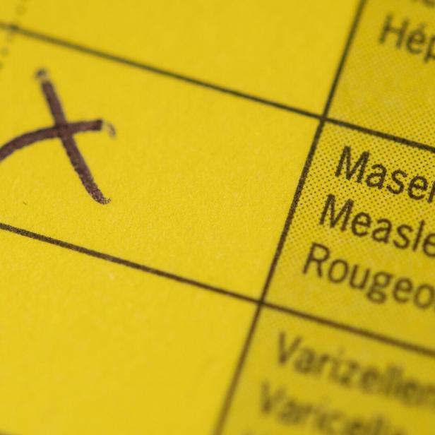 Ein aufgeschlagener Impfpass mit einem Kreuz im Masernfeld.