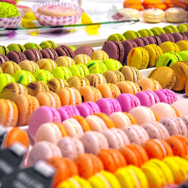 Eine Auslage mit bunten Macarons in verschiedenen Geschmacksrichtungen.