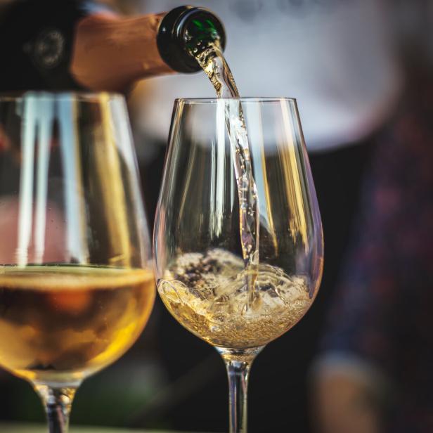 Rosé-Champagner wird in ein Glas gegossen.