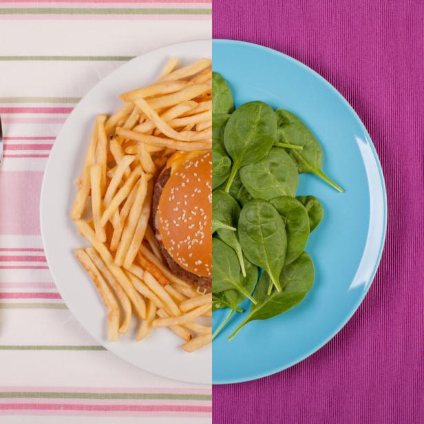 Ein Teller mit Burger und Pommes neben einem Teller mit Spinat, geteilt durch eine Farbgrenze.
