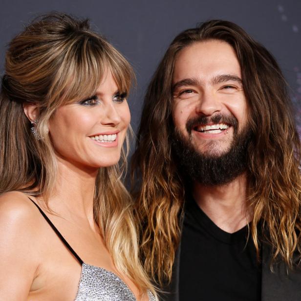 Heidi Klum und Tom Kaulitz lächeln auf einem roten Teppich.
