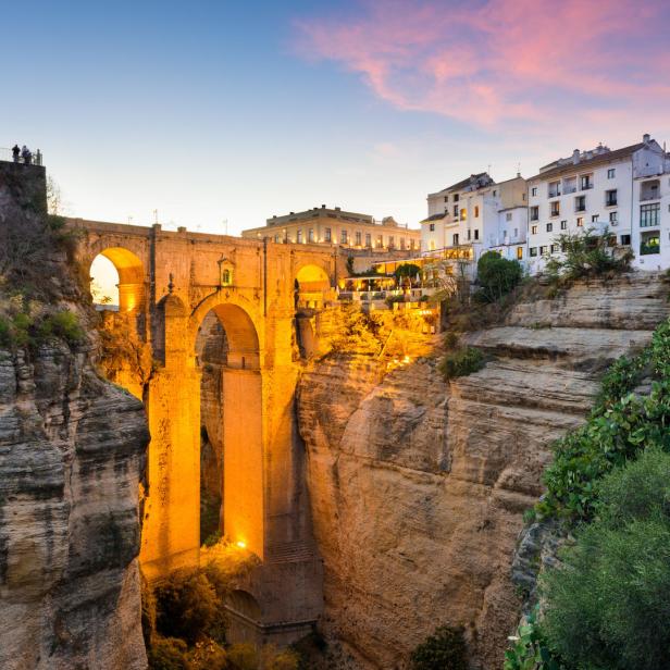 Die Puente Nuevo Brücke in Ronda, Spanien, erstrahlt im Abendlicht.