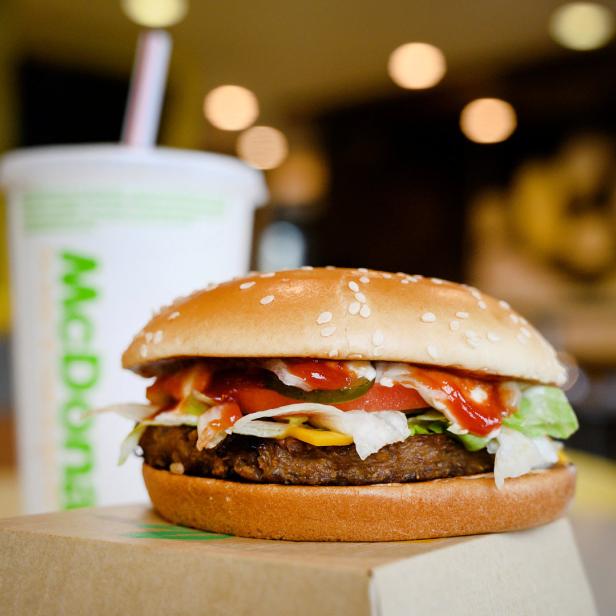 Ein Burger von McDonald's steht neben einem Softdrink.