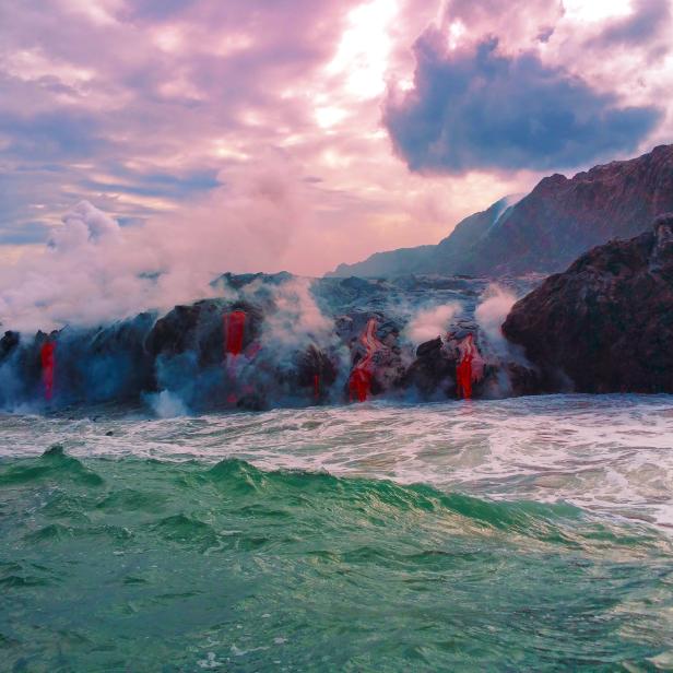 Lava fließt ins Meer und erzeugt Dampf unter einem bewölkten Himmel.