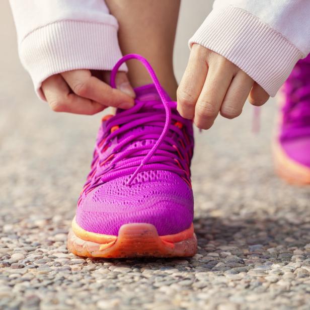 Läuferin schnürt Laufschuhe.