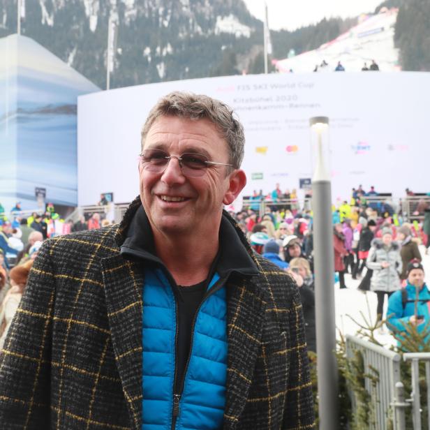 Ein lächelnder Mann steht vor einer Zuschauermenge beim FIS Ski World Cup in Kitzbühel.