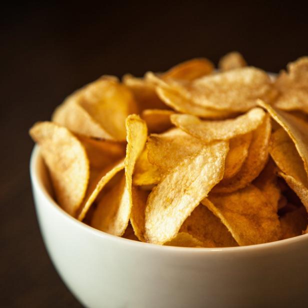 Eine Schüssel ist gefüllt mit goldgelben Kartoffelchips.