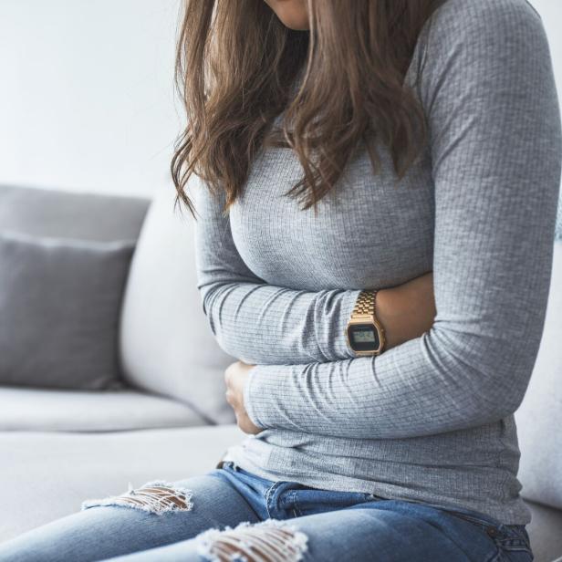 Woman lying on sofa looking sick in the living room
