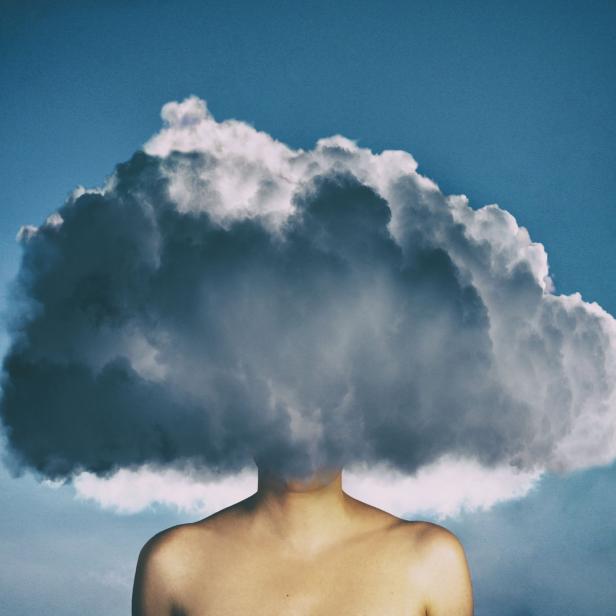 Eine Wolke verdeckt den Kopf einer Person vor einem blauen Himmel.