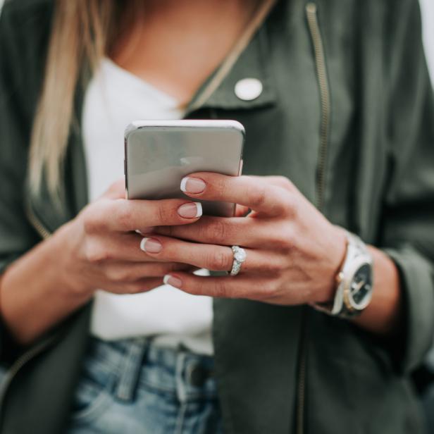 Symbolbild: Eine Frau bedient ihr Smartphone.