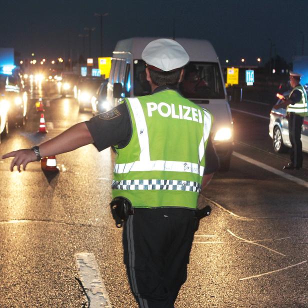 Ein Polizist leitet den Verkehr bei einer nächtlichen Kontrolle auf der Autobahn.