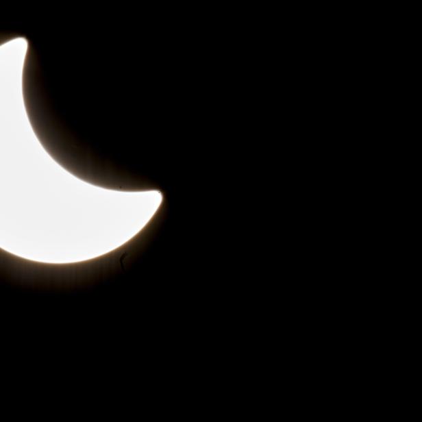 Eine partielle Sonnenfinsternis vor einem schwarzen Hintergrund.