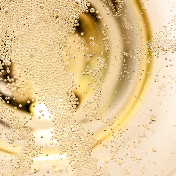 Nahaufnahme von Champagnerblasen in einem Glas.