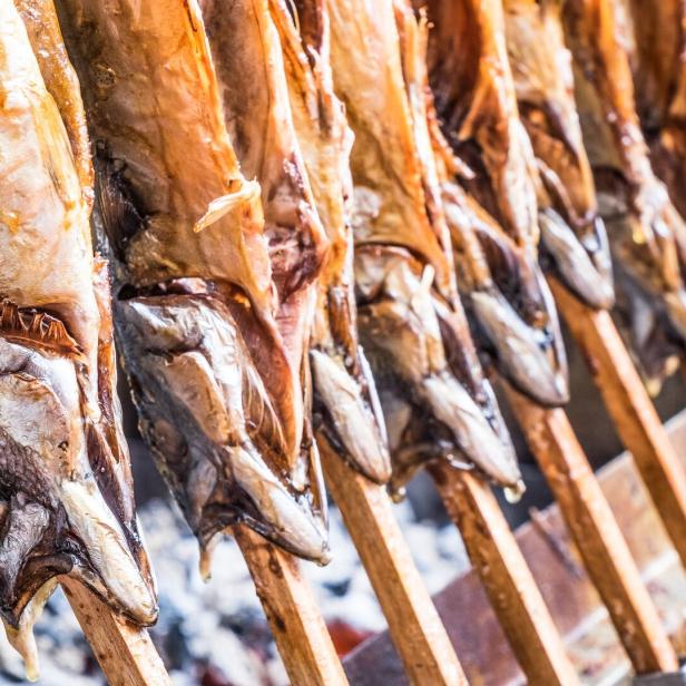 Gegrillter Steckerlfisch auf Holzstäben wird zum Verkauf angeboten.
