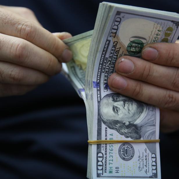 Ein Mann zählt US-Dollar-Scheine