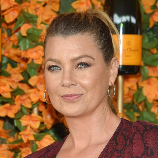 Ein Porträt von Ellen Pompeo vor einem Hintergrund aus Blumen und einer Champagnerflasche.