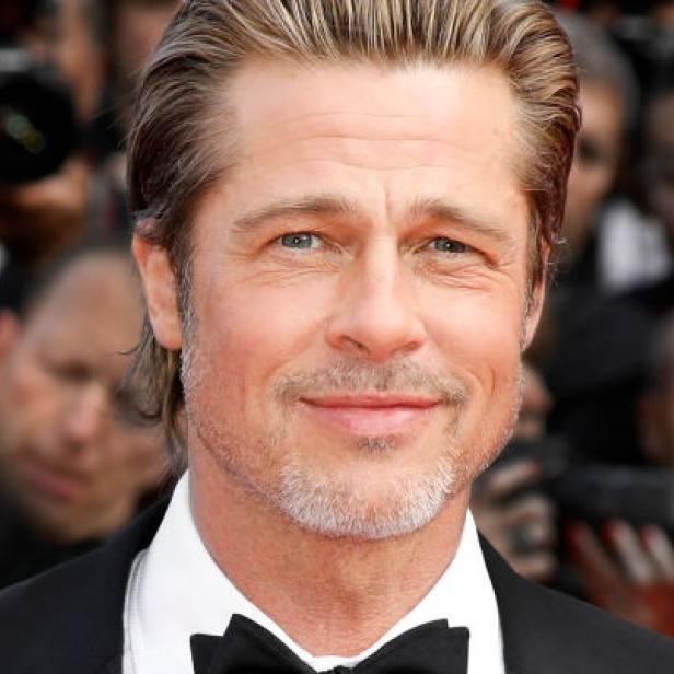Porträt von Brad Pitt mit Fliege auf einem roten Teppich.