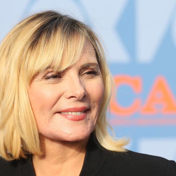 Ein Porträt von Kim Cattrall mit blonden Haaren und einem schwarzen Blazer.