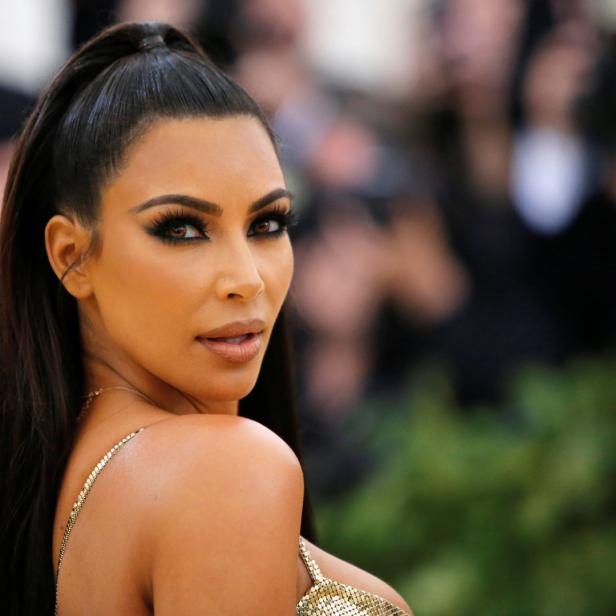 Kim Kardashian blickt über ihre Schulter in die Kamera.