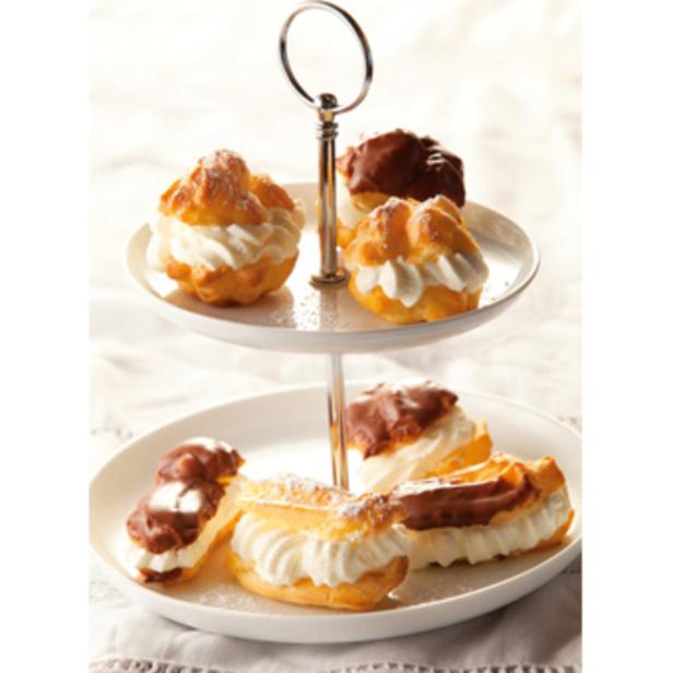 Windbeutel und Eclairs mit Schlagsahne auf einer Etagere.