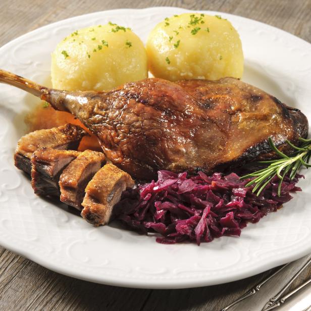 Ein Teller mit knuspriger Martinsgans, Kartoffelknödeln und Rotkohl.