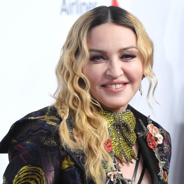 Ein Porträt von Madonna mit blonden Locken und einem verzierten Blazer.