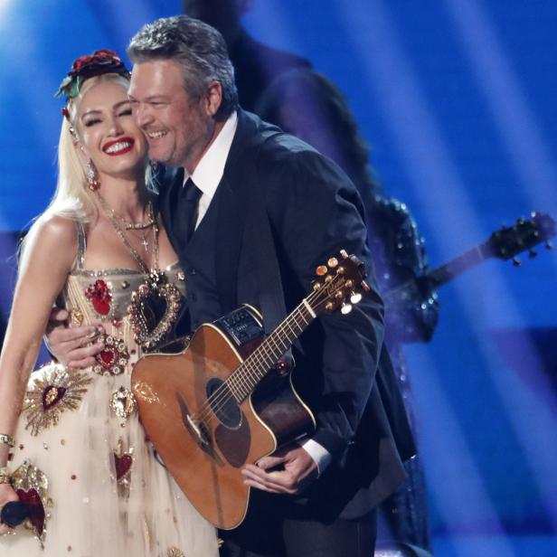 Gwen Stefani und Blake Shelton umarmen sich auf einer Bühne.