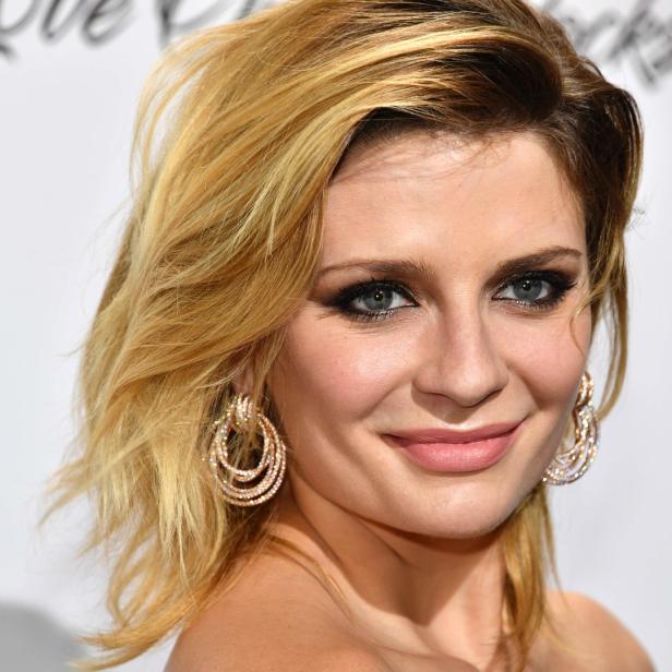 Ein Porträt von Mischa Barton mit blonden Haaren und auffälligen Ohrringen.