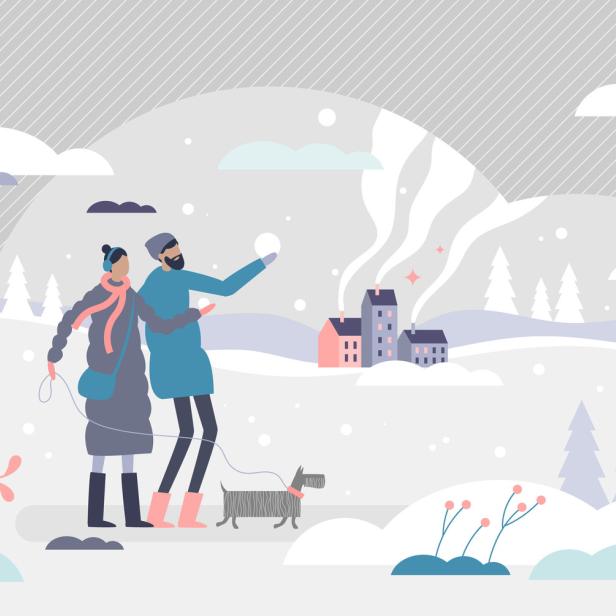 Ein Paar spaziert mit einem Hund durch eine verschneite Winterlandschaft.