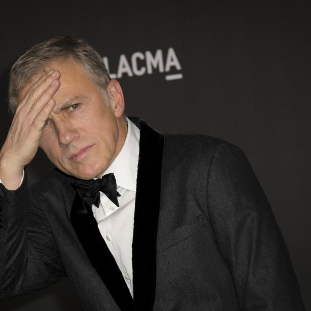Christoph Waltz bei einer Veranstaltung des LACMA mit einer Hand auf der Stirn.