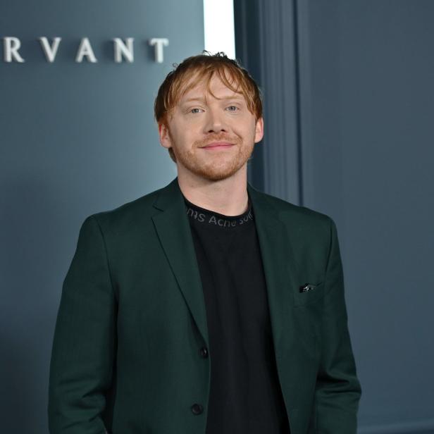 Rupert Grint vor einer Wand mit der Aufschrift „Servant“.