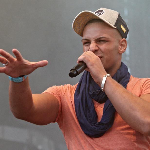 Pietro Lombardi singt mit einem Mikrofon in der Hand.