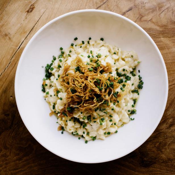 Eine Schüssel mit Spätzle, garniert mit Röstzwiebeln und Schnittlauch.