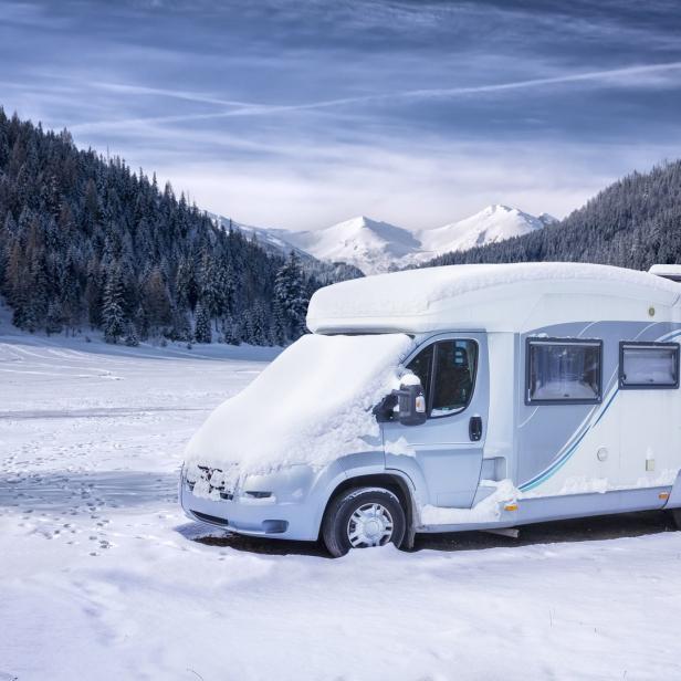 Ein Wohnmobil ist im Winter mit Schnee bedeckt.