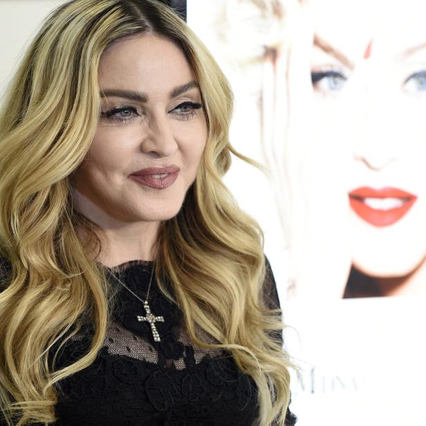 Madonna posiert vor einem Poster von sich selbst.