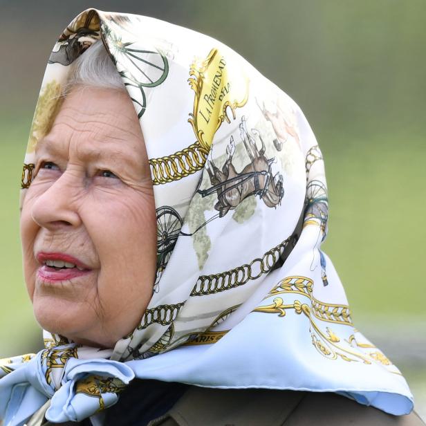 Königin Elizabeth II. mit einem gemusterten Kopftuch.
