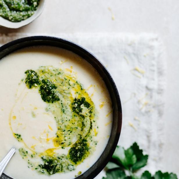 Eine Schüssel cremige Suppe mit Pesto und einem Klecks Öl wird von oben gezeigt.