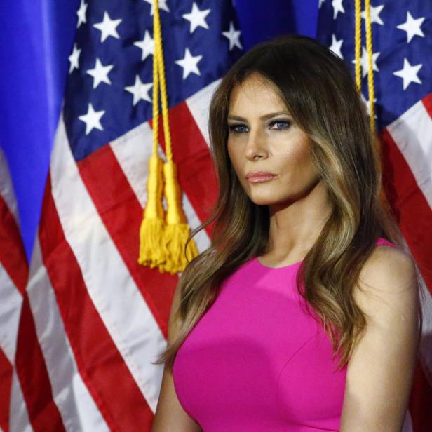 Melania Trump posiert im pinken Kleid vor der amerikanischen Flagge