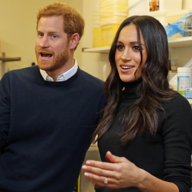 Prinz Harry und Meghan, die Herzogin von Sussex, gestikulieren in einem Raum.