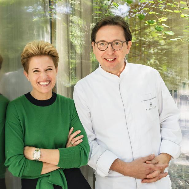 Heinz und Birgit Reitbauer vor einer Glaswand.